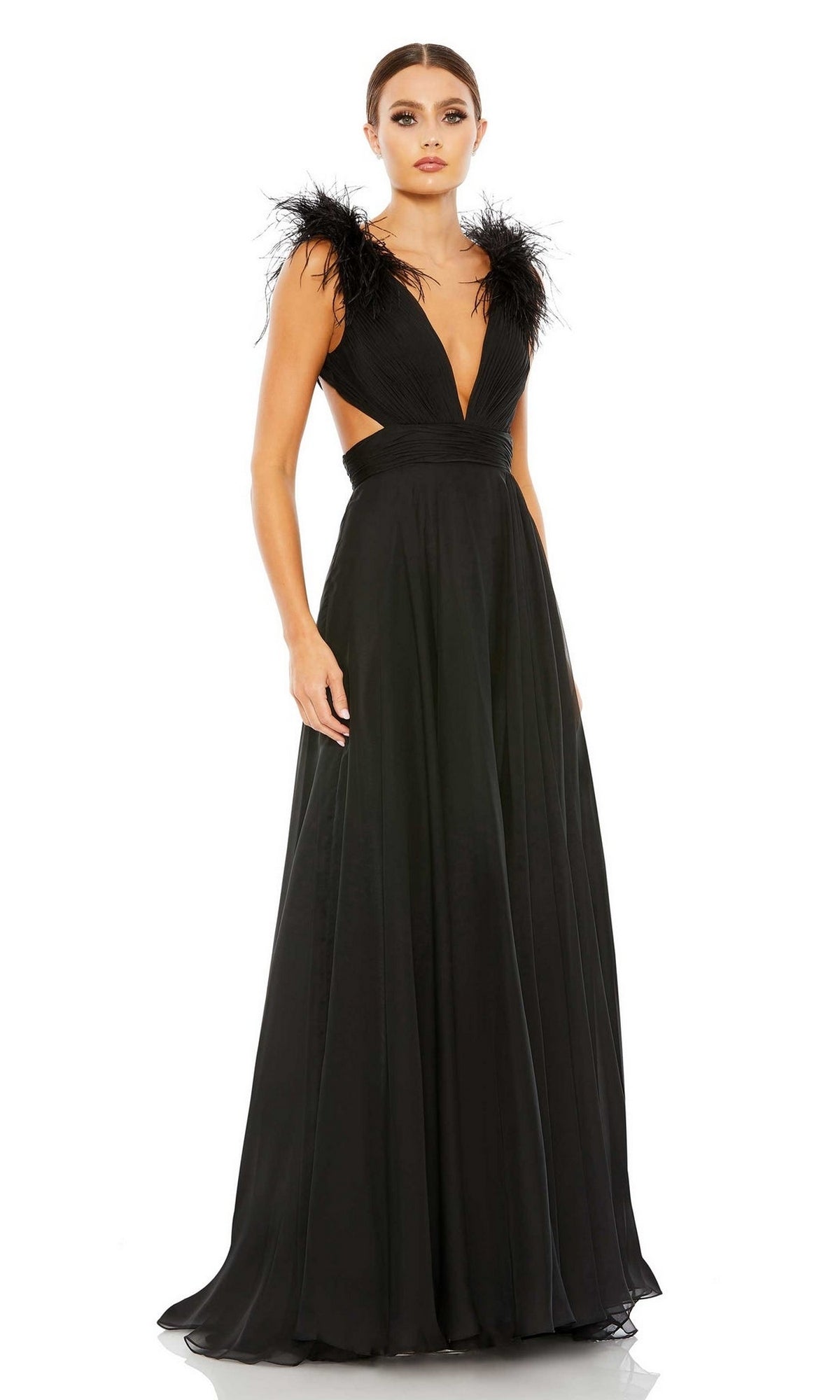 A woman wears the Mac Duggal 68113 Feather-Trim Long Formal Dress, featuring a strappy open back, deep V-neckline, feathered shoulders, and flowing skirt, as she stands against a plain background.